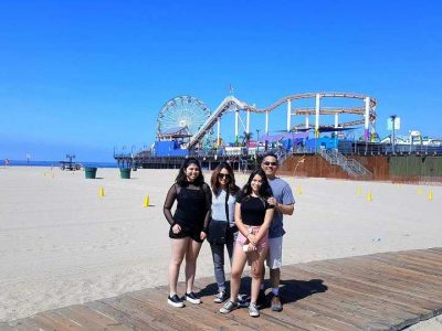 family of four standing near amusement park in los angeles beaches