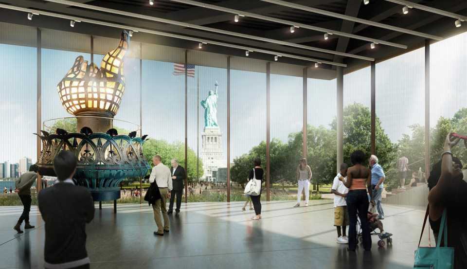 People standing inside a glass building looking at statues