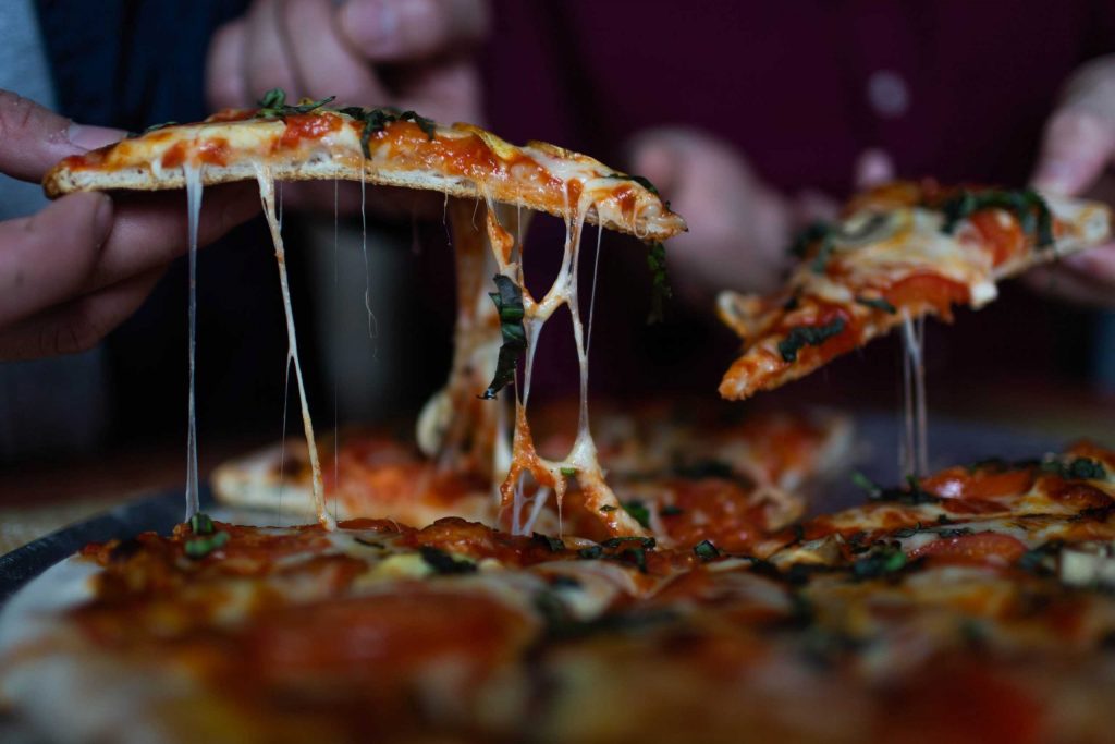 Pizza with cheese dripping from it