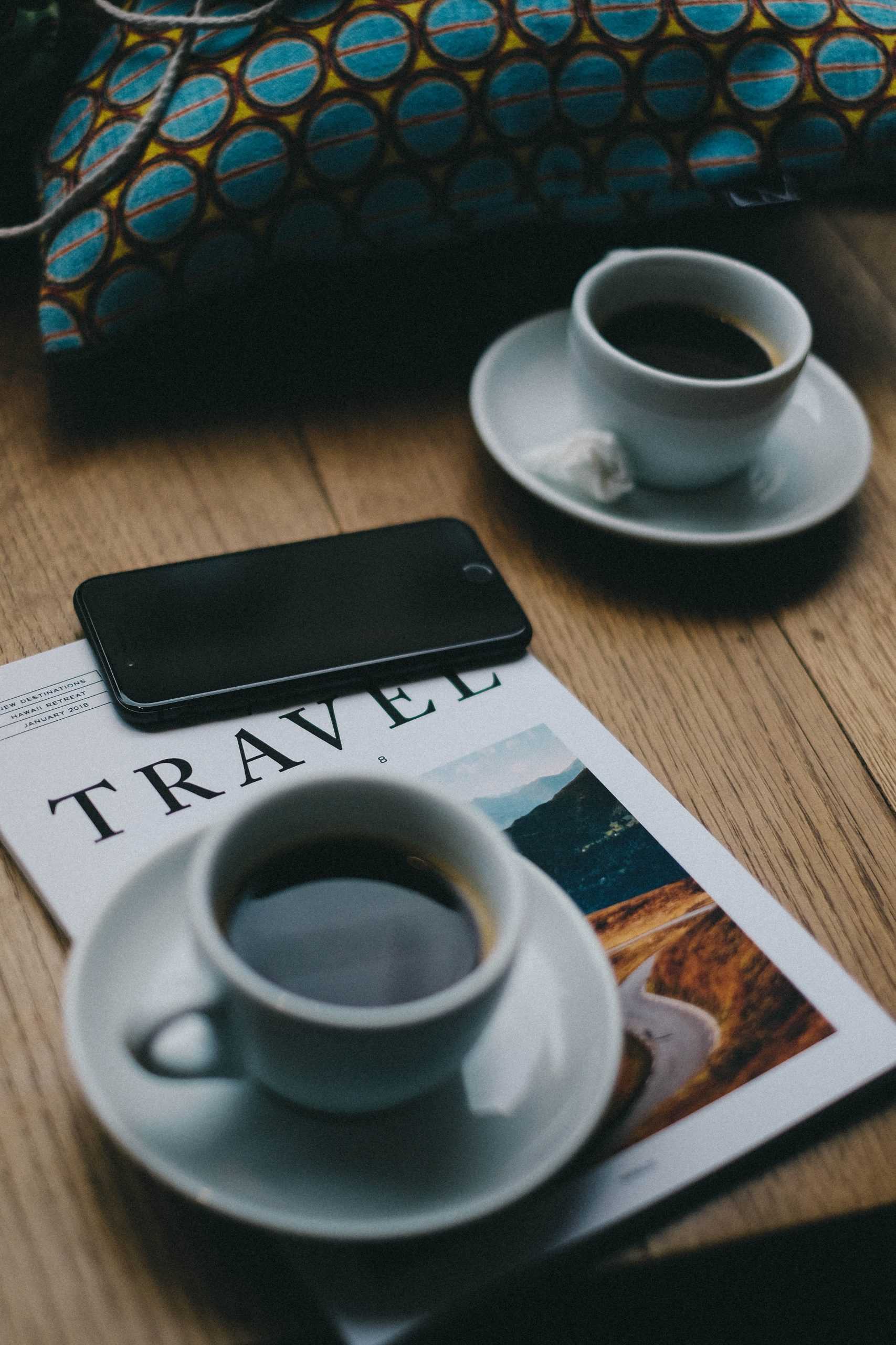 magazine on a table with cups of coffee