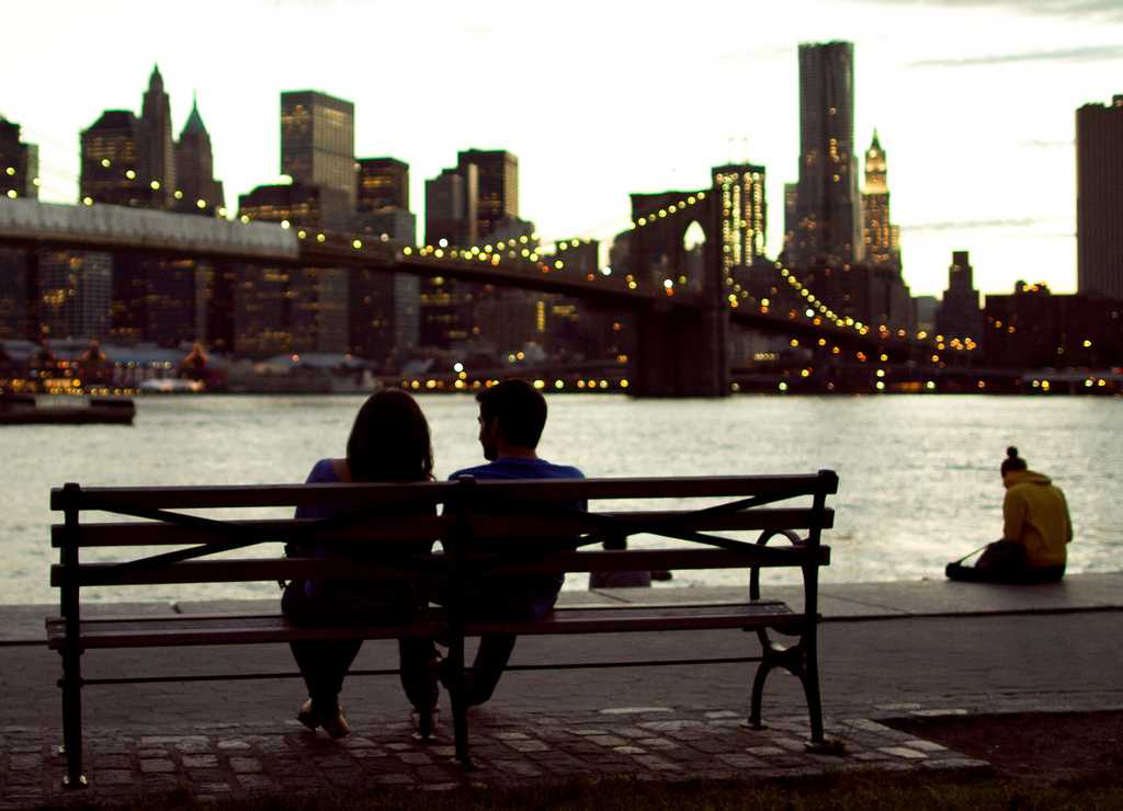 couple sitting on bench overlooking NYC