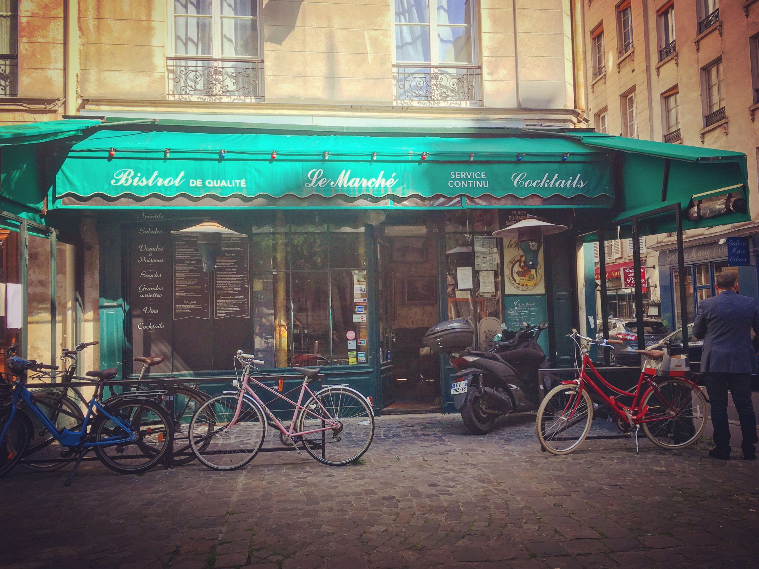 Green awning for bistro Le Marche with bicycles parked outside