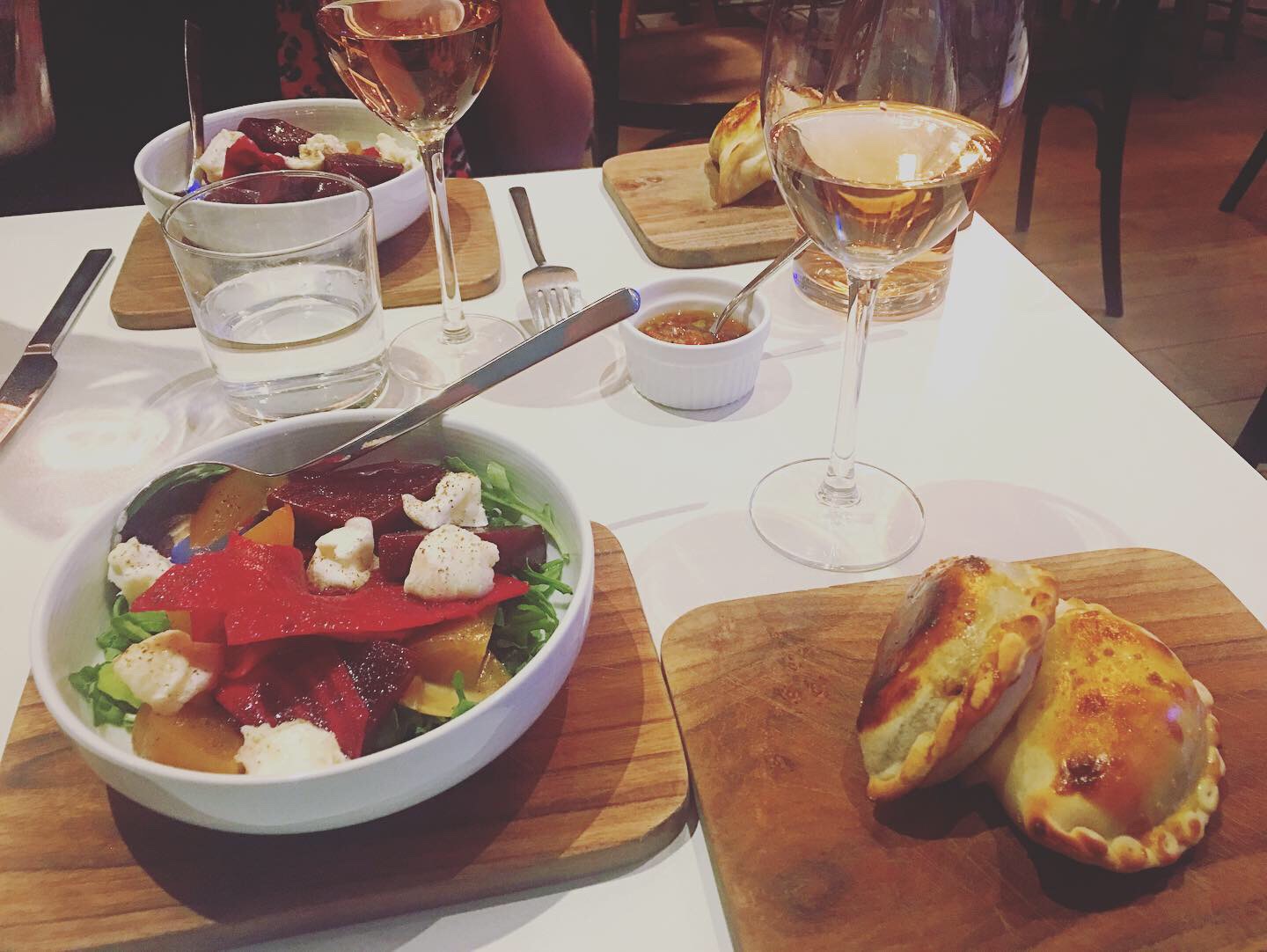 Empanadas, a small salad and wine set at the table