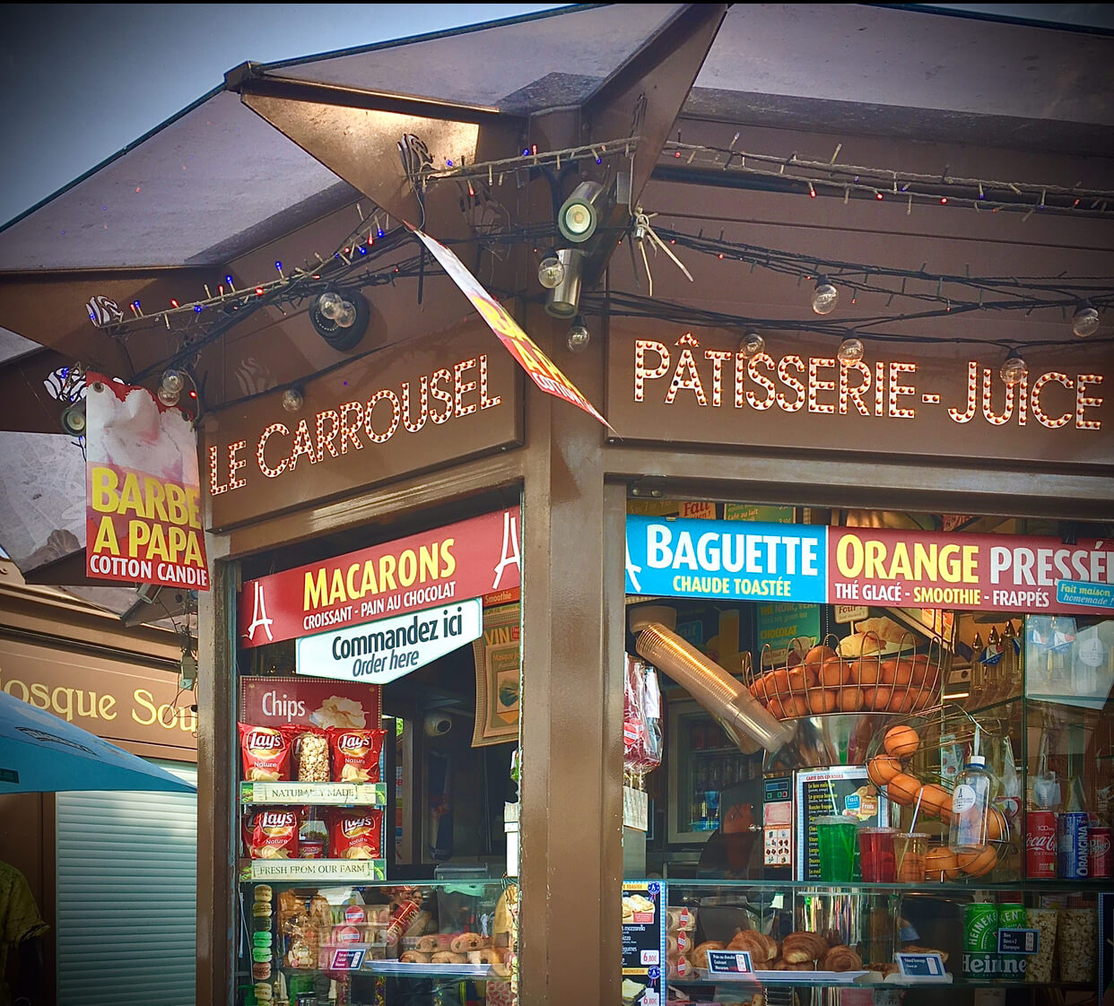 A kiosk with signs advertising snacks and snacks on display