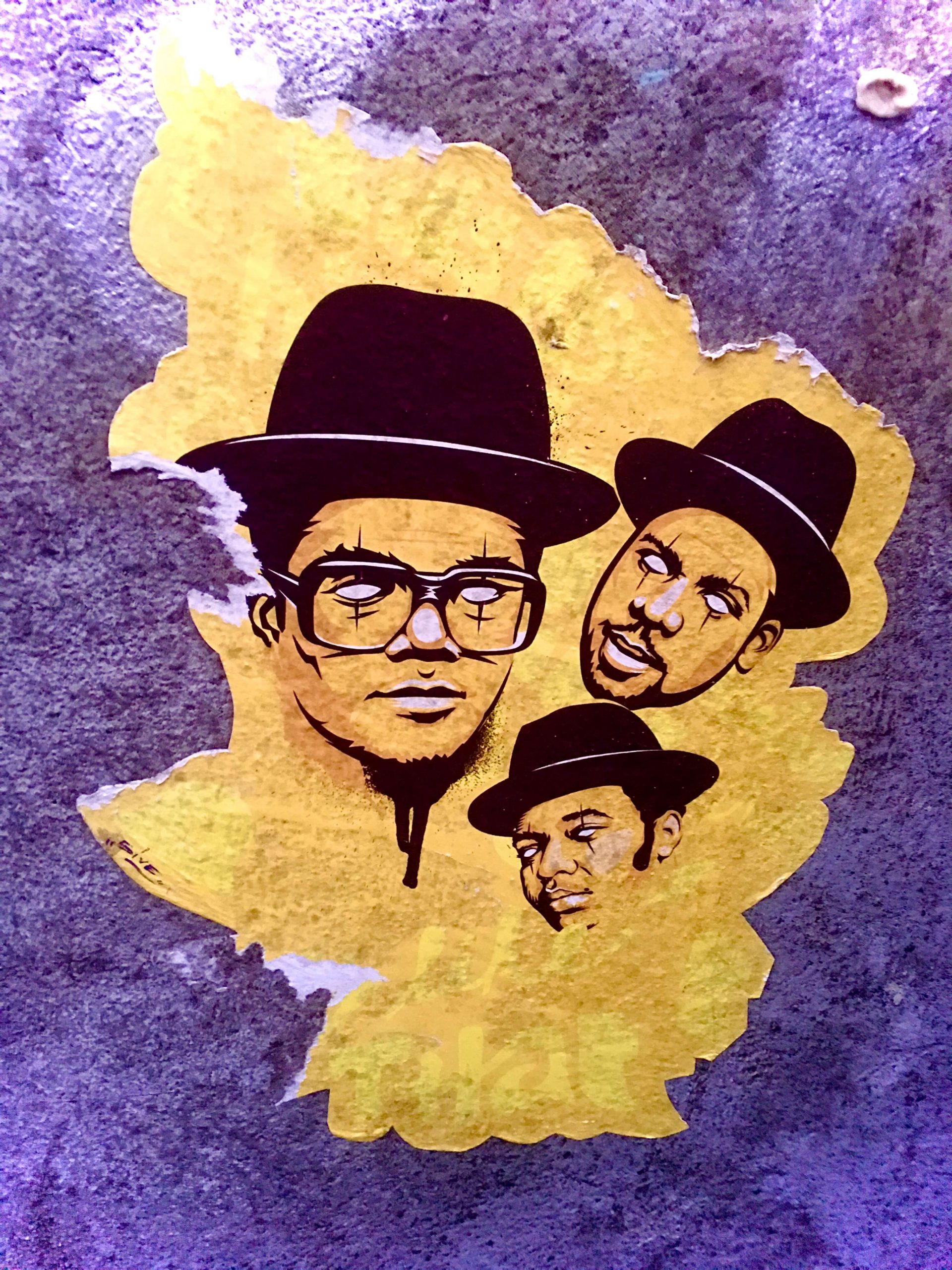 Run DMC wearing black fedoras in a street art piece