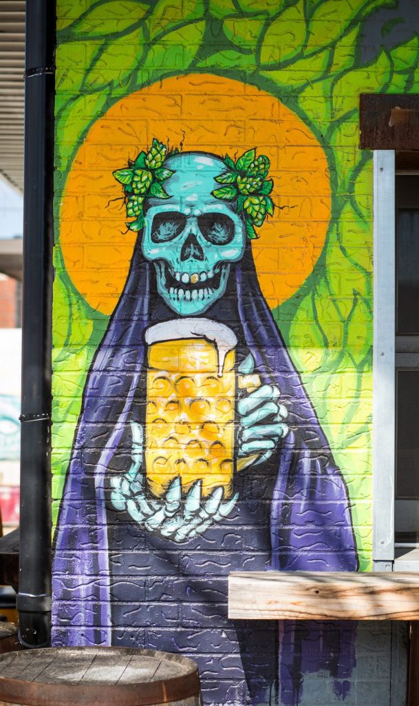Mural in Deep Ellum of a skeleton drinking a beer