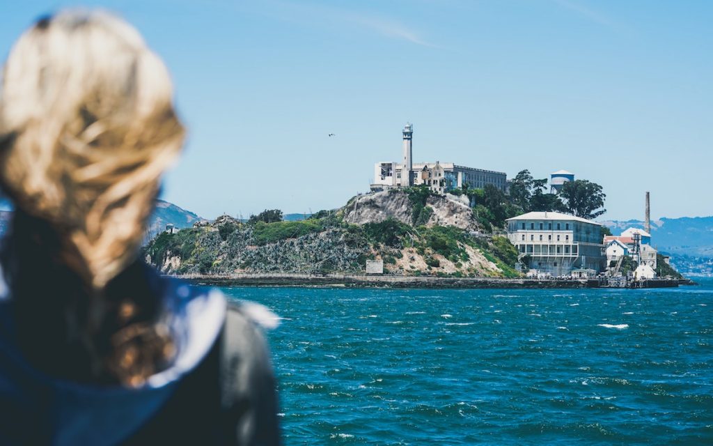 Woman looking at alcatraz island from on board the alcatraz cruise