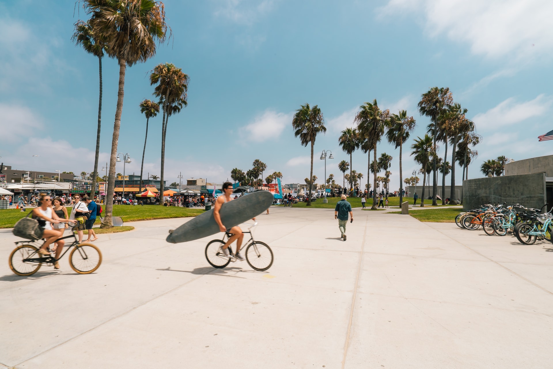 surfer and bicyclists at venice beach, california