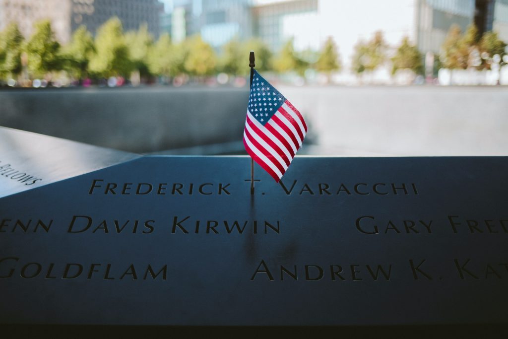 9/11 Memorial with American flag by fountain in NYC