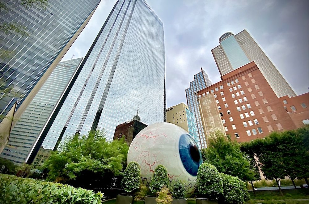 Giant-Eyeball-in-Dallas-surrounded-by-greenery-and-skyscrapers-1000×660