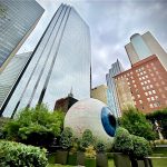 Giant Eyeball in Dallas surrounded by greenery and skyscrapers