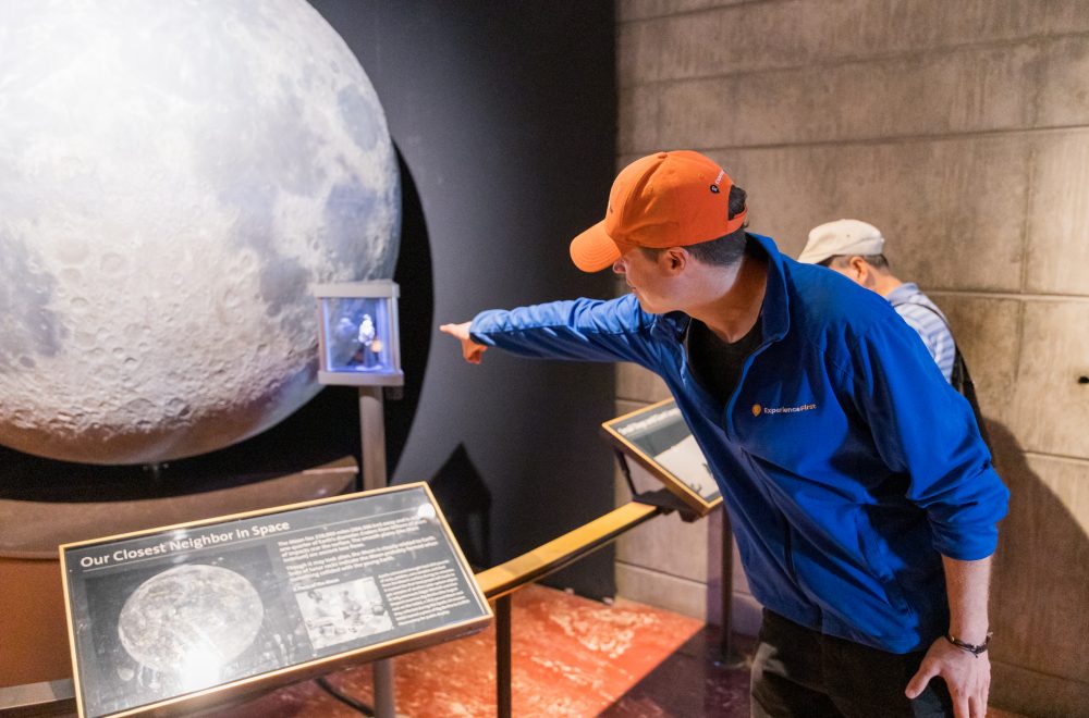 Tour Guide pointing at Moon Display in Griffith Observatory