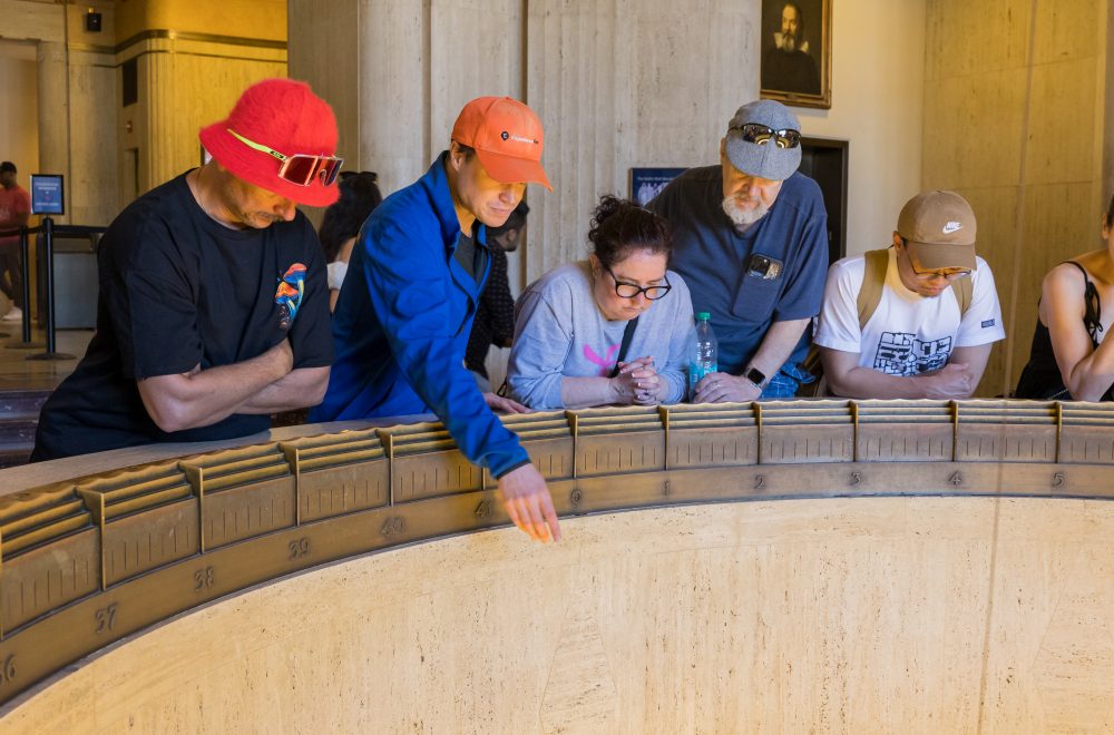 Tour guide and guests looking below inside the Griffith Observatory