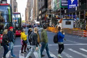 Tour group with guide crossing the road during NYC in a Day Tour