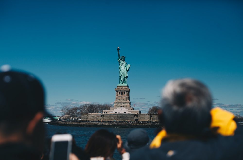 tourists looking at the statue of liberty from the Staten Island ferry