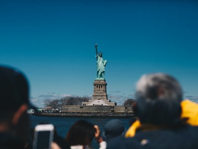 tourists looking at the statue of liberty from the Staten Island ferry