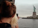 Tourists looking at Statue of Liberty from ferry