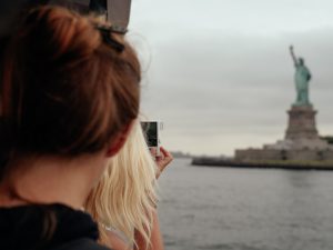 Tourists looking at Statue of Liberty from ferry