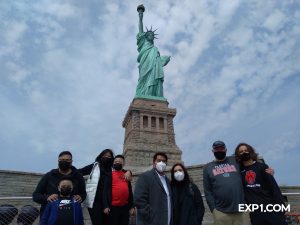 tour group in front of the statue of liberty in nyc