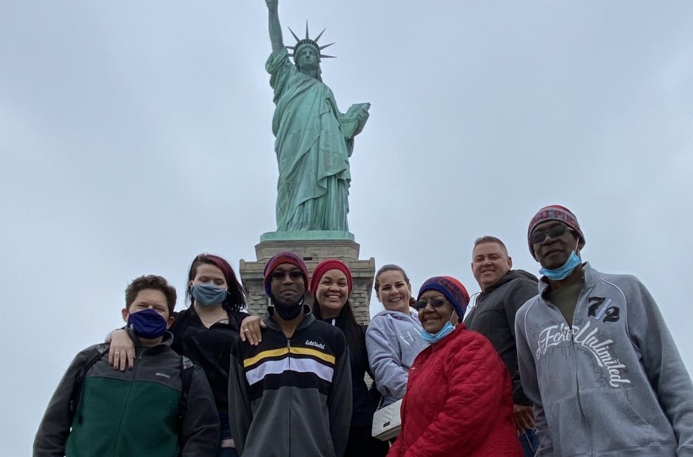 Tour group with the statue of liberty in NYC