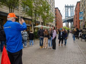 Tour guide taking photo of guests in Brooklyn, Bronx, Queens Bus Tour