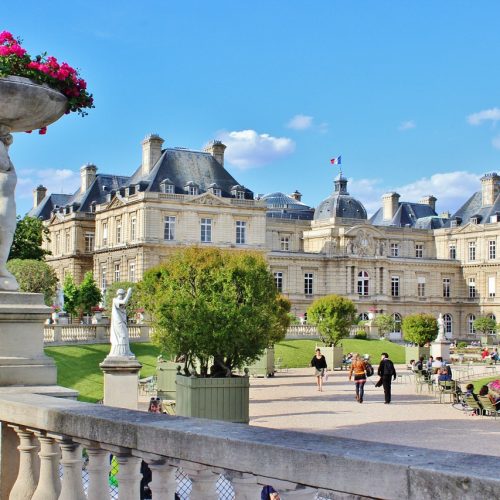 Luxembourg Gardens with cherubs holding flower pots in foreground and palace in the background