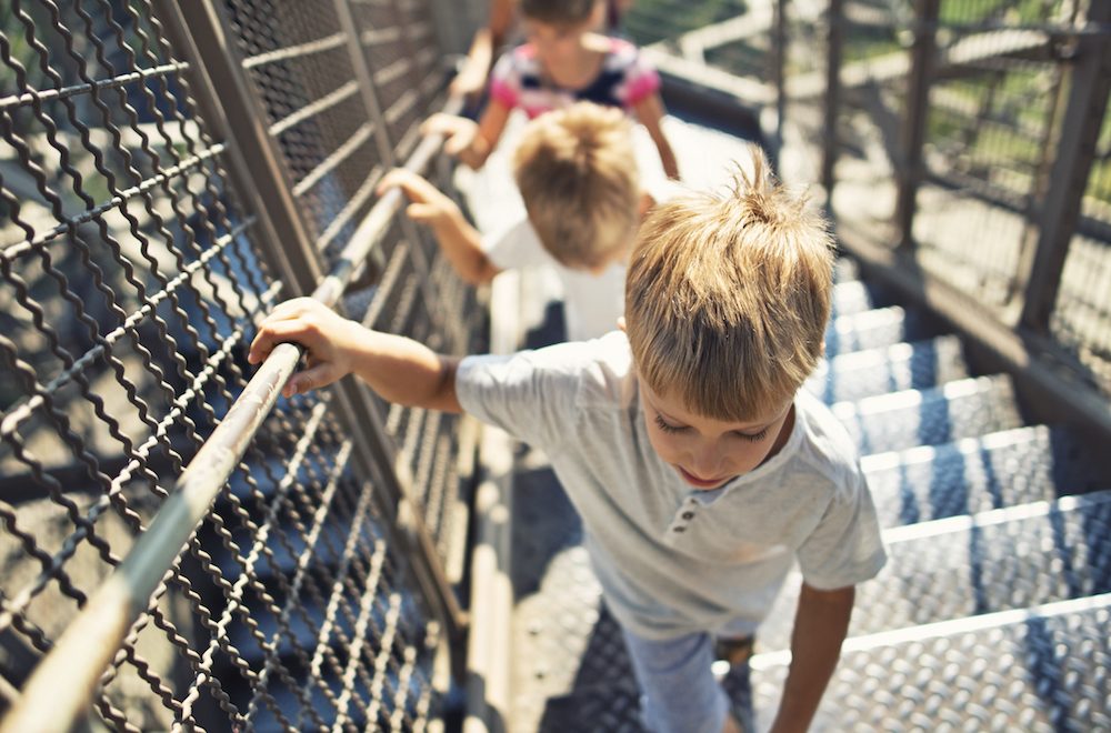 Eiffel Tower tour group with kids climbing to the second level of the tower