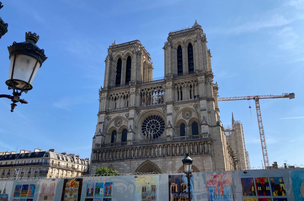 Notre Dame front with wall and drawings and lamp post