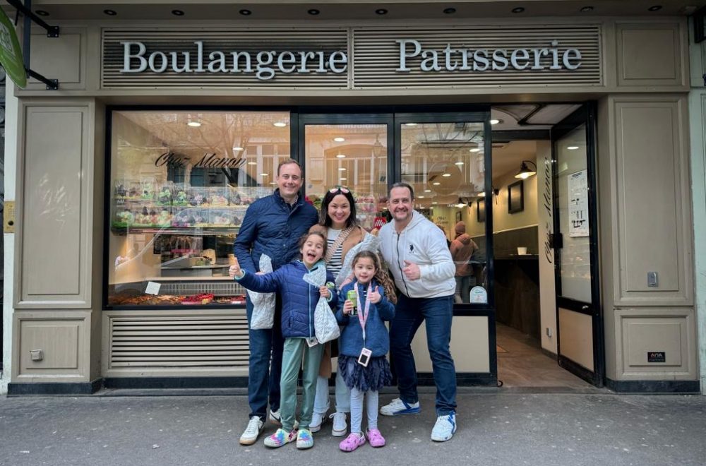 Family posing for photo after hands-on French baking class