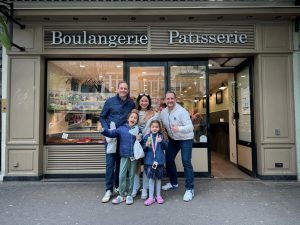 Family posing for photo after hands-on French baking class