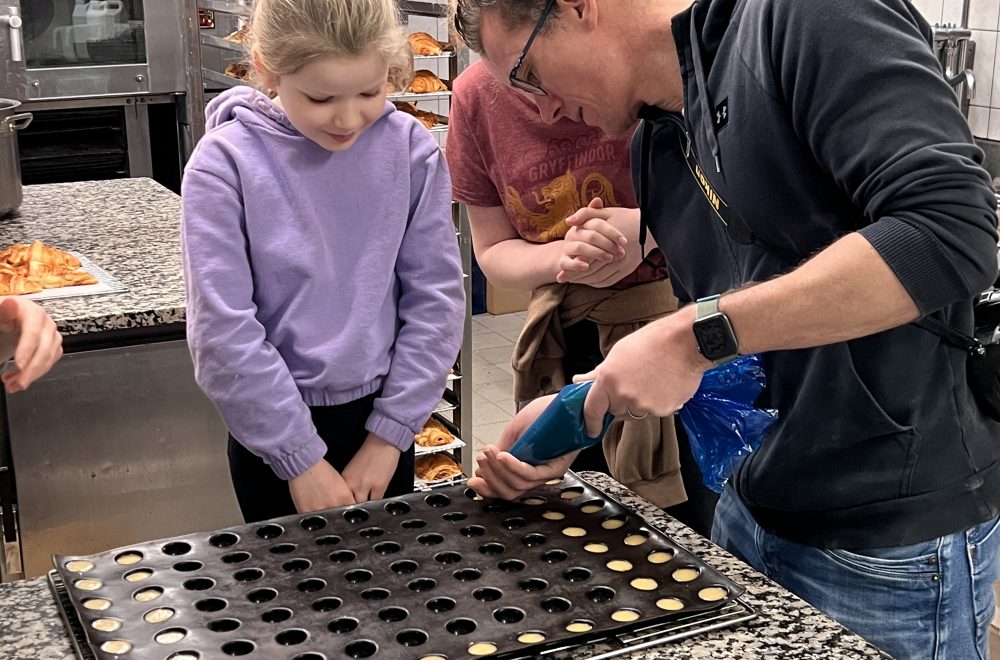 Father and daughter piping into tray