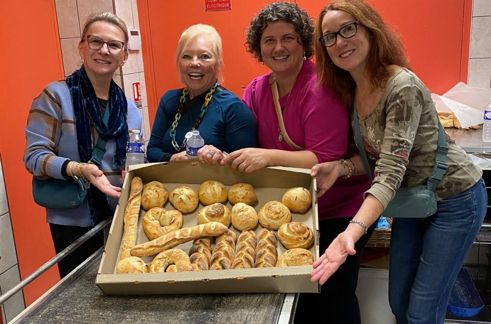 Guests posing with tray of freshly baked bread