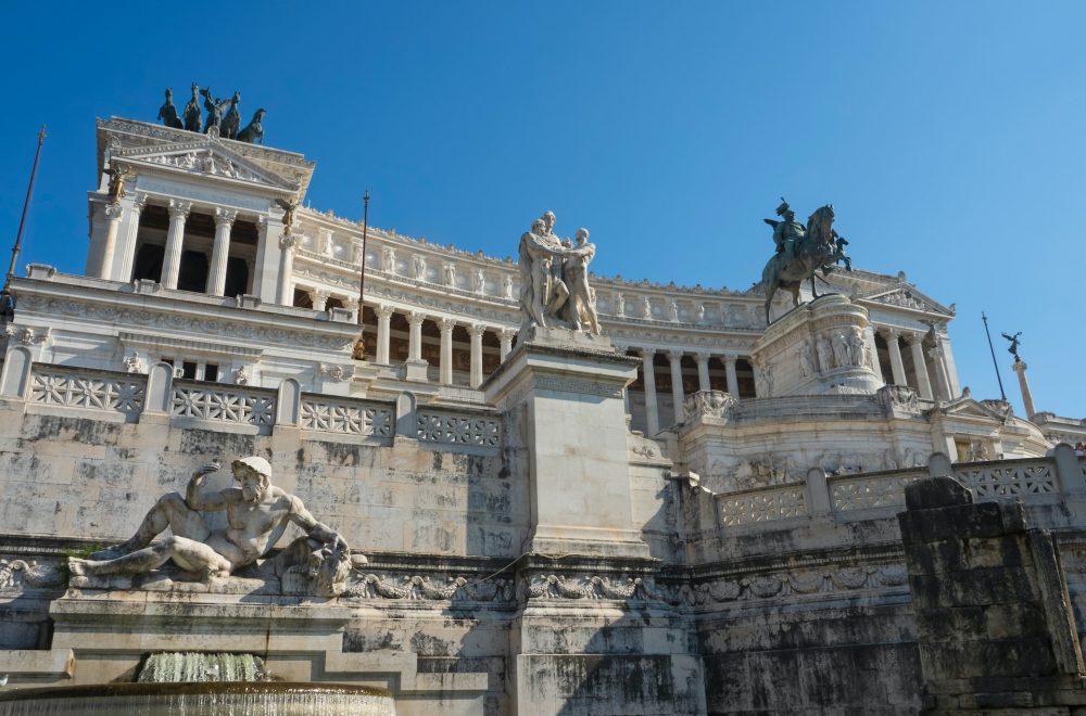 a large stone building with statues on top