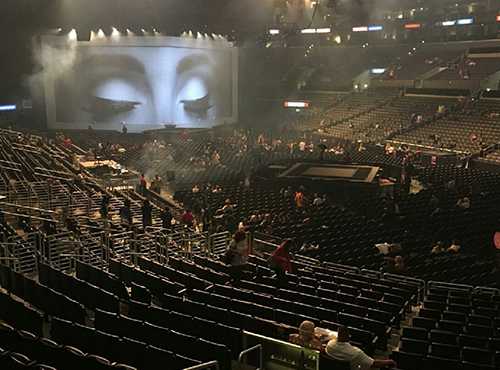 Concert seats, stage, big screen with woman's eyes