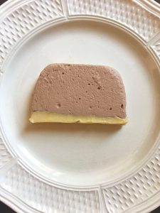 A slice of duck liver pâté on a white plate