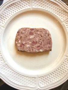 A white plate with a slice of pâte e campagnie