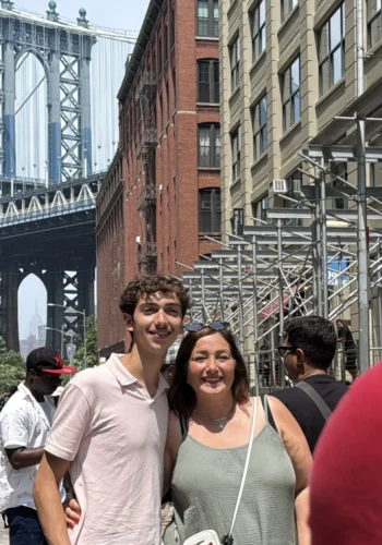 Two people taking a photo with Brooklyn Bridge during Beyond Manhattan private guided tour