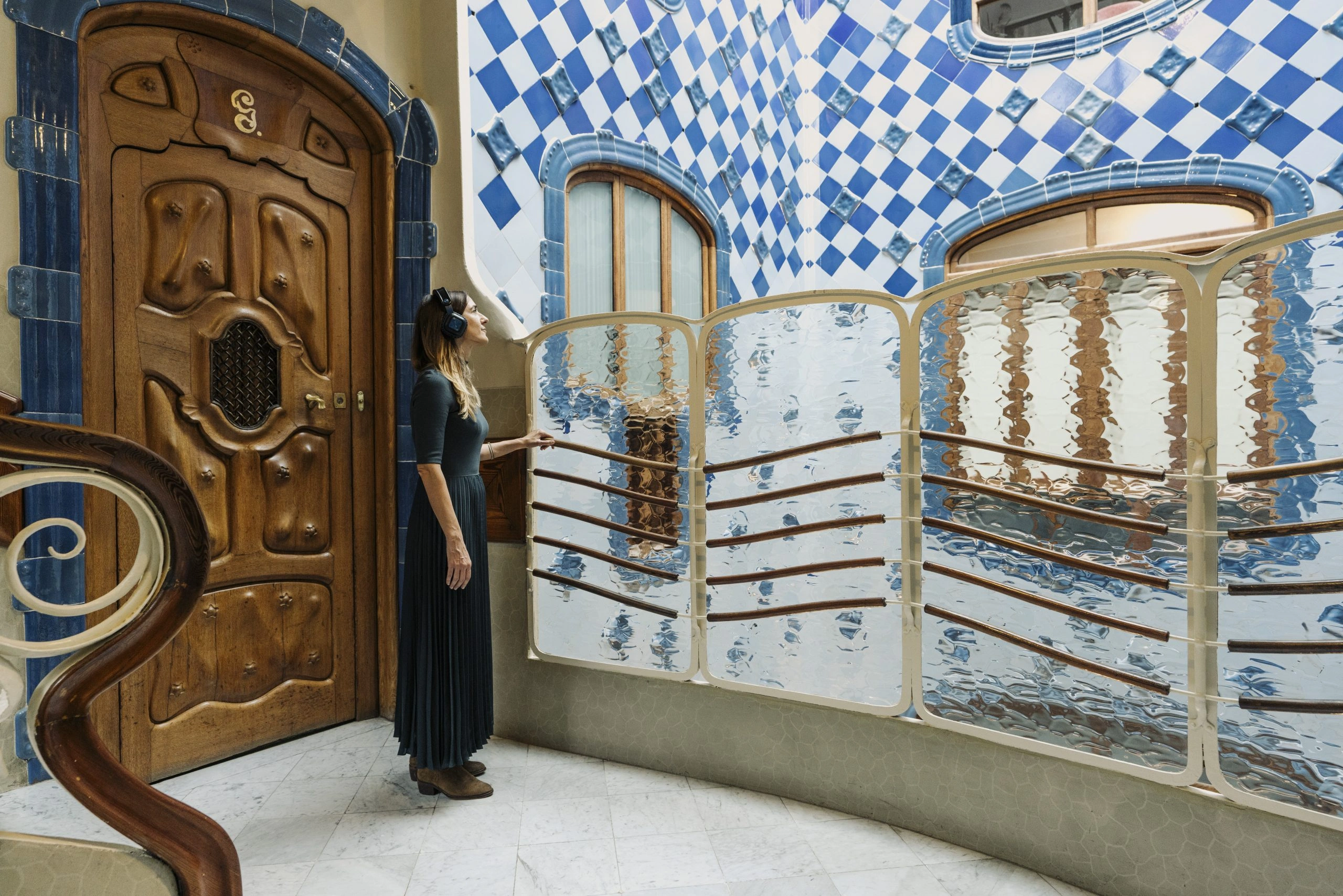 Woman listening to audio guide in Casa Batllo Insider Tour