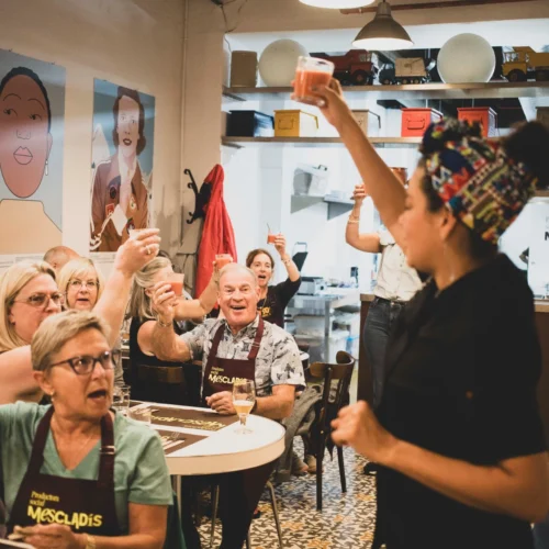 Host cheering group in dining area during cooking class in Barcelona