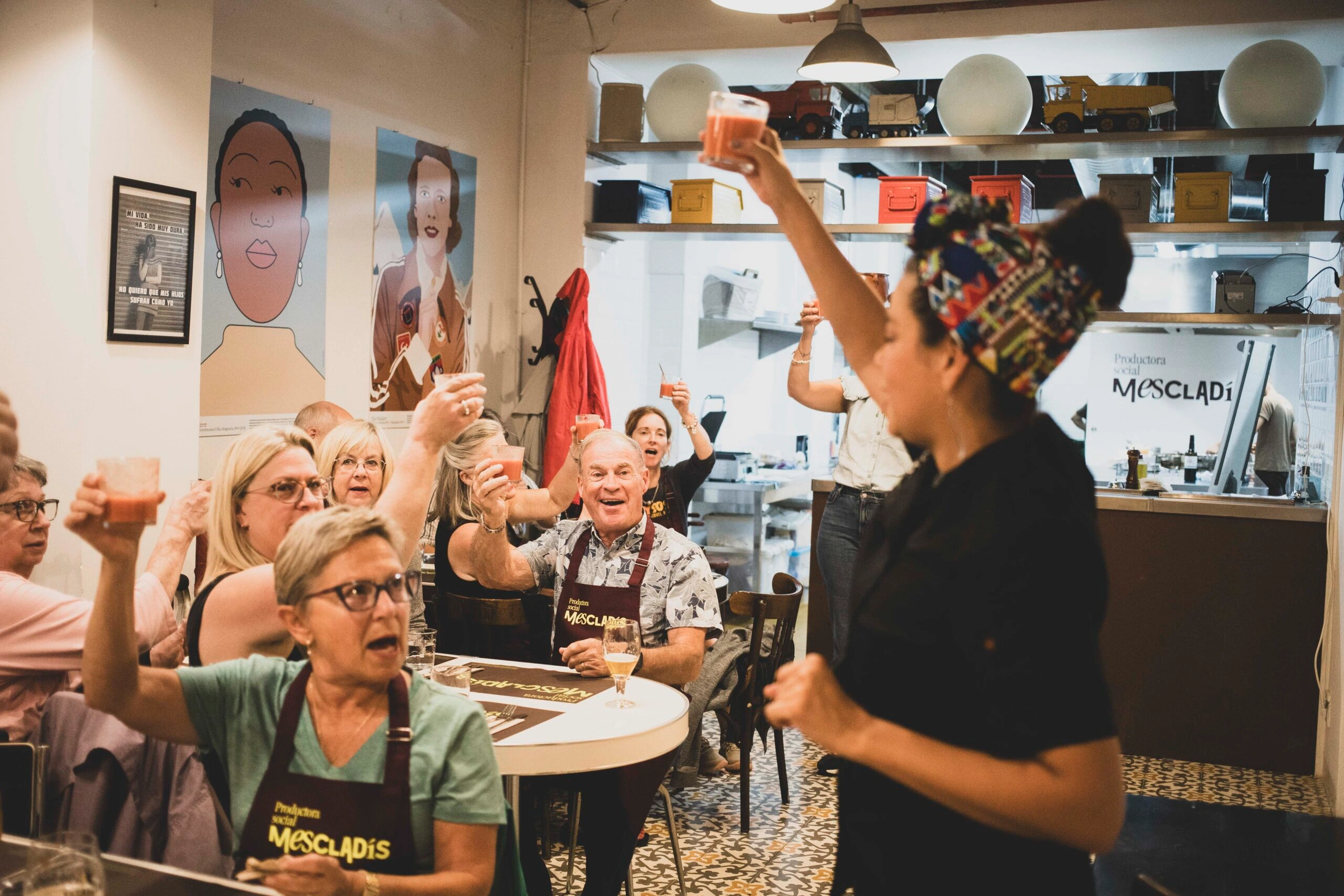 Host cheering group in dining area during cooking class in Barcelona