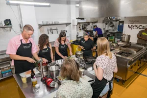 In action cooking shot of group during cooking class in Barcelona
