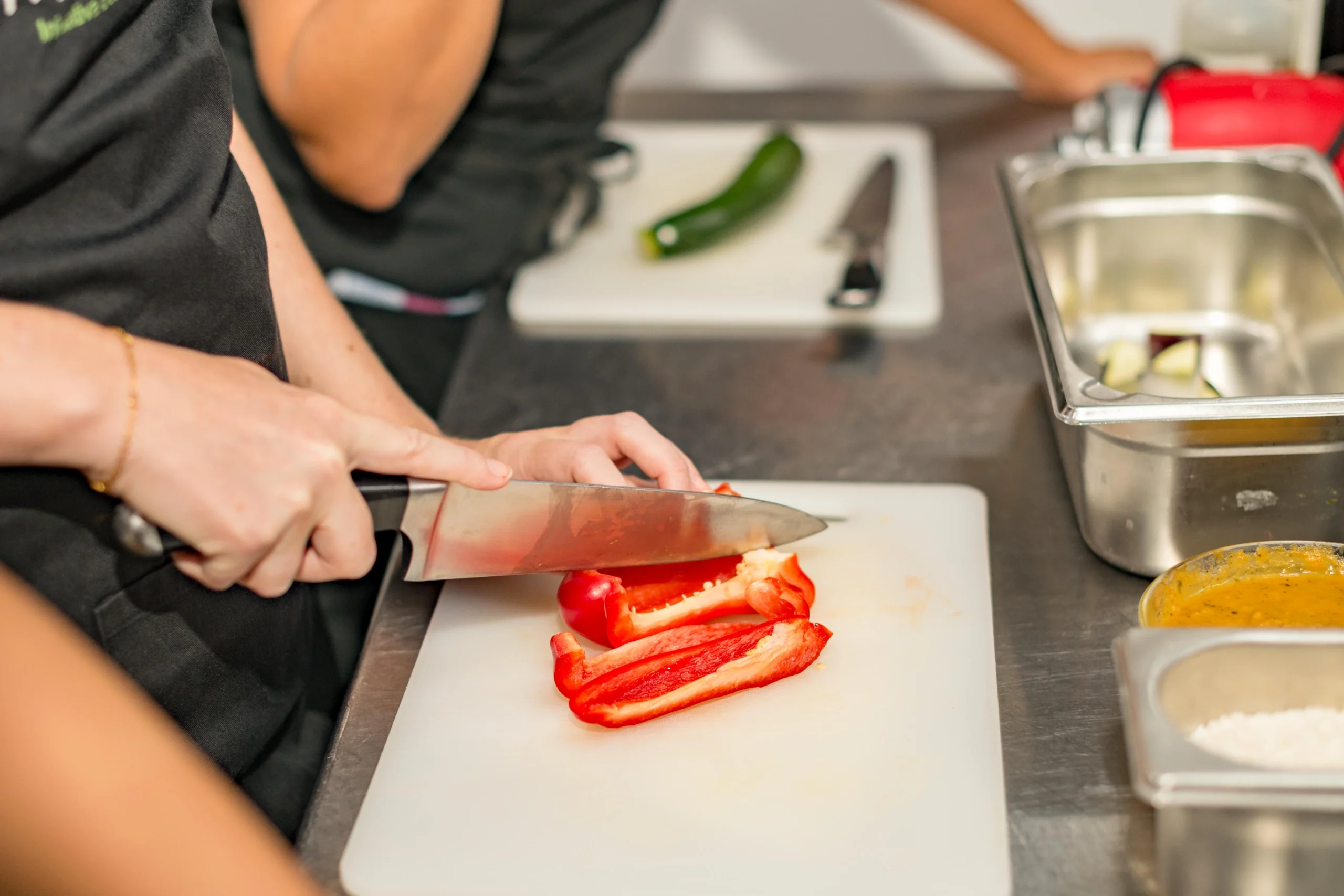 Traveler chopping red bell pepper during cooking class
