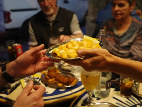 Hand passing tapas across table