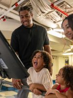 Family interacting with an exhibit at the USS Midway Museum in San Diego
