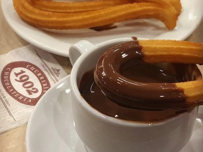 Churro dipped in chocolate at Churros and hot chocolate at Chocolatería 1902
