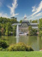 Panoramic of the Crystal Palace in the Retiro Park of Madrid with the cloudy sky