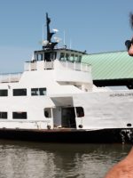 Man and Statue of Liberty cruise boat during Statue of Liberty and Ellis Island tour