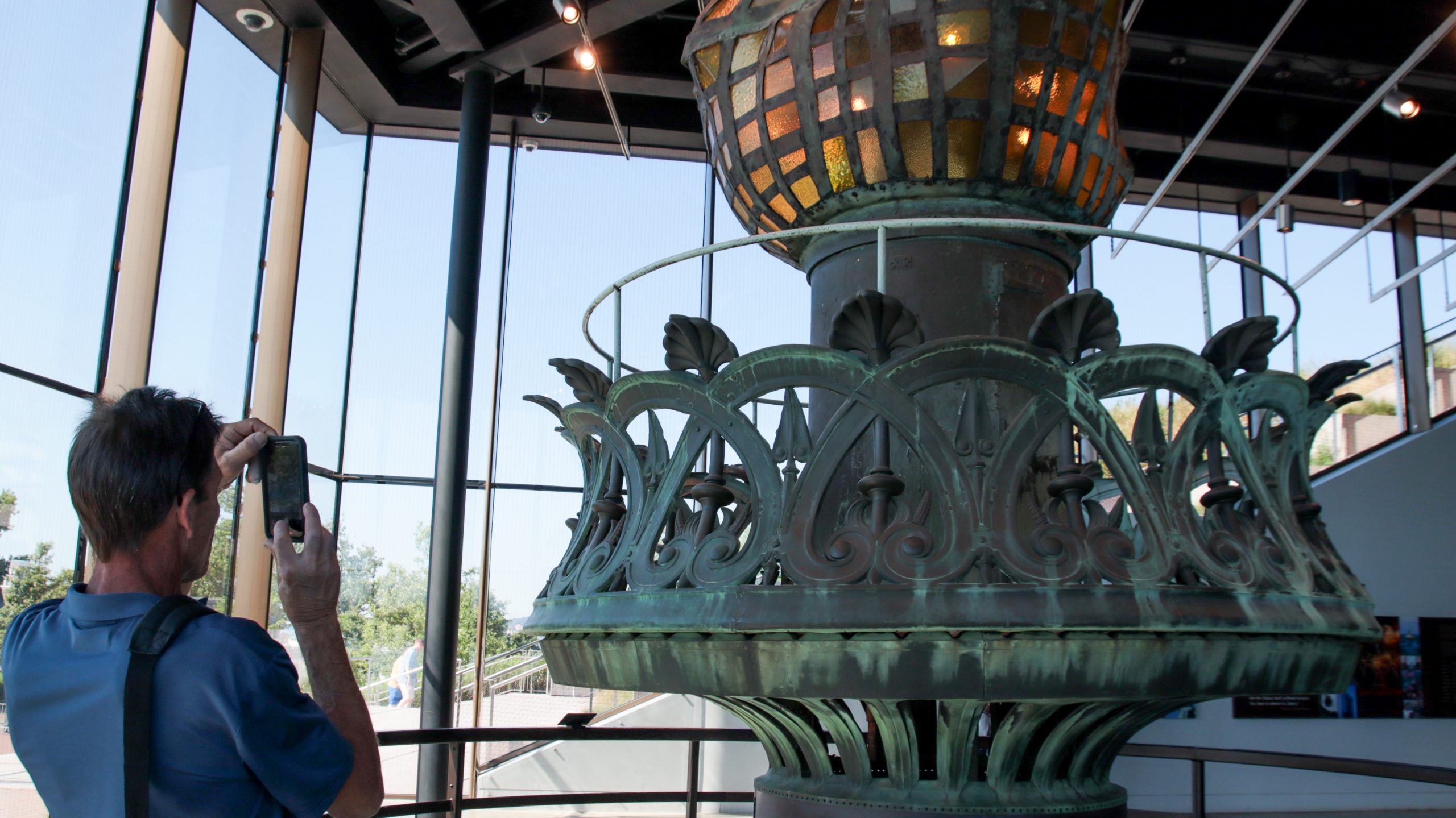 Man taking photo of artifact in Statue of Liberty museum