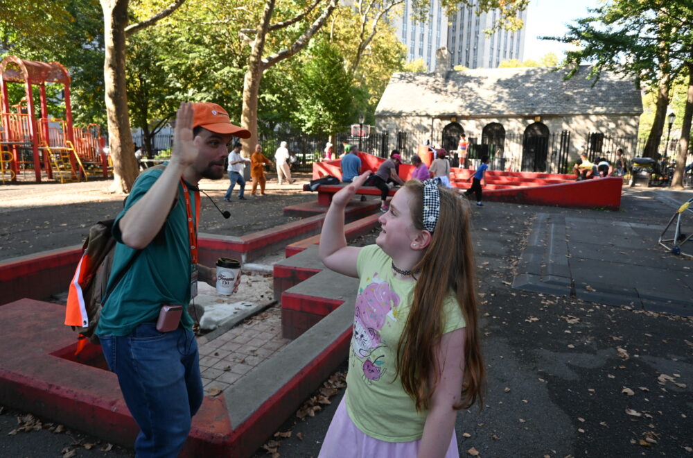 Tour guide high-fiving little girl during tour in New York City