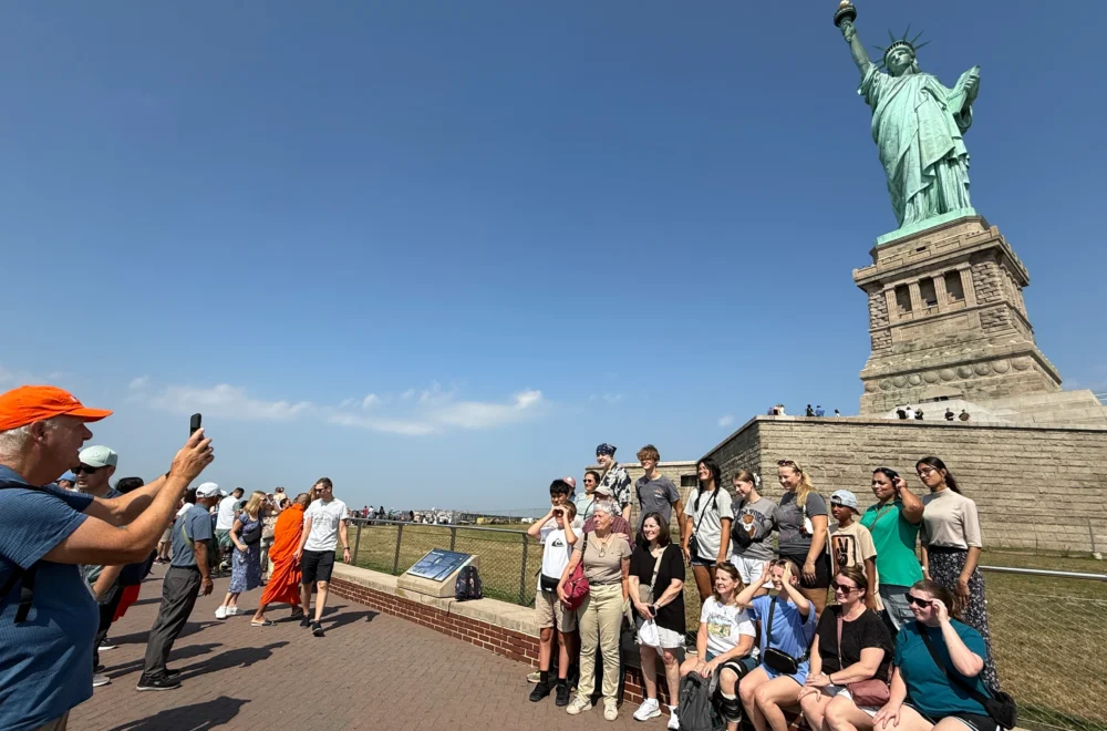 Tour guide taking photo of guests during Statue of Liberty and Ellis Island tour
